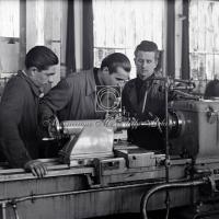 Operai al lavoro su macchinario industriale